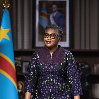 Judith SUMINWA TULUKA devant le drapeau national